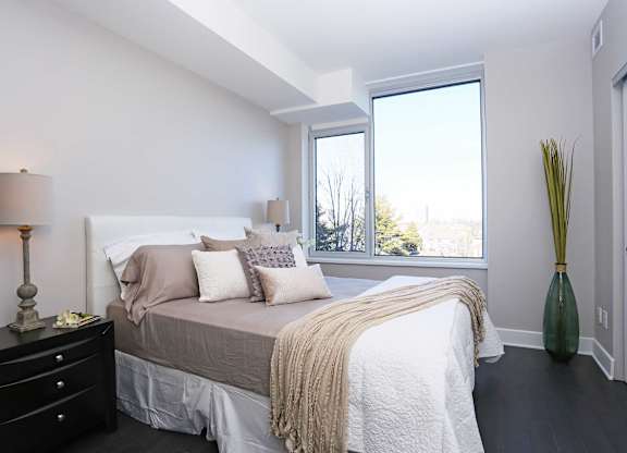 a bedroom with a bed and a large window