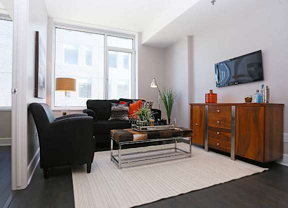a living room with a black couch and a television