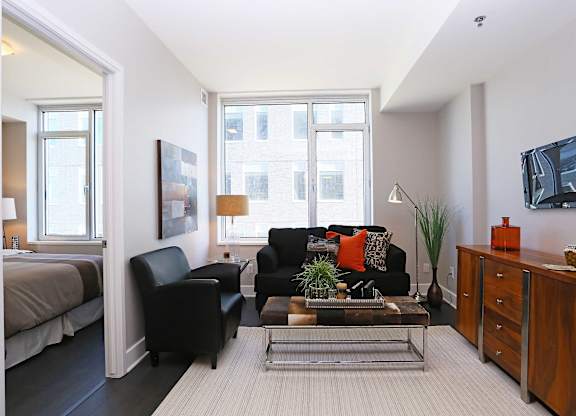 a living room with a couch and a table in front of a window