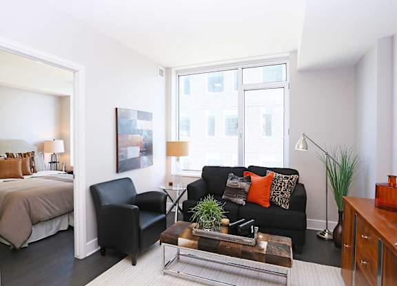 a living room with a couch and a table and a bedroom