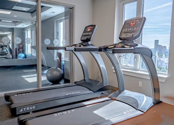 the gym has a treadmill and a view of the city