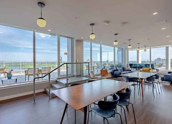 a communal area with tables and chairs and large windows