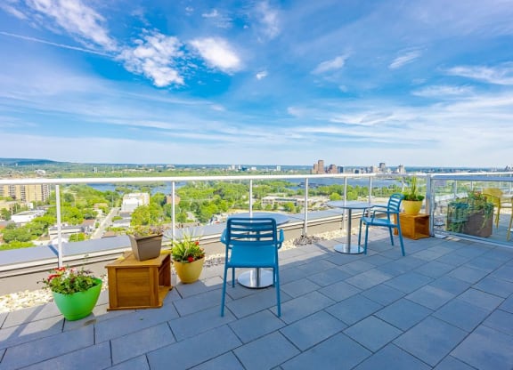 a balcony with blue chairs and a view of the city