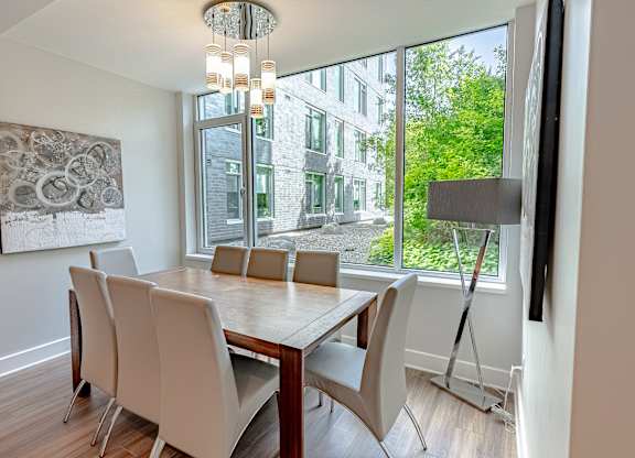 a dining room with a large window and a table with chairs