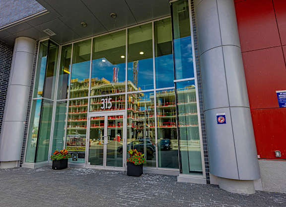 the front of a glass building with a reflection of a building in the window