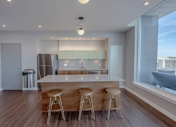 a kitchen with a marble counter top and three bar stools
