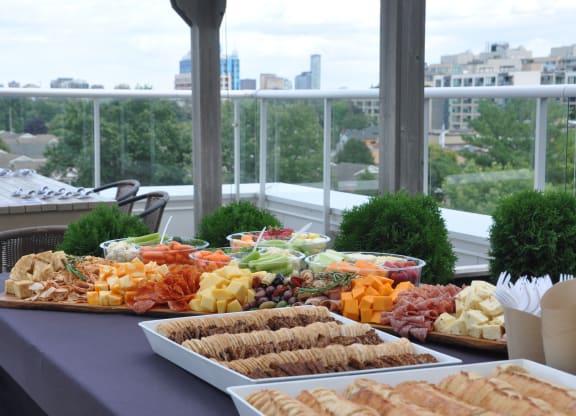 a buffet of food on a table with a city in the background