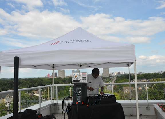 a man standing under a white tent on top of a roof