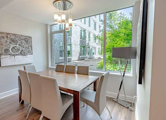 a dining room with a large window and a table with chairs