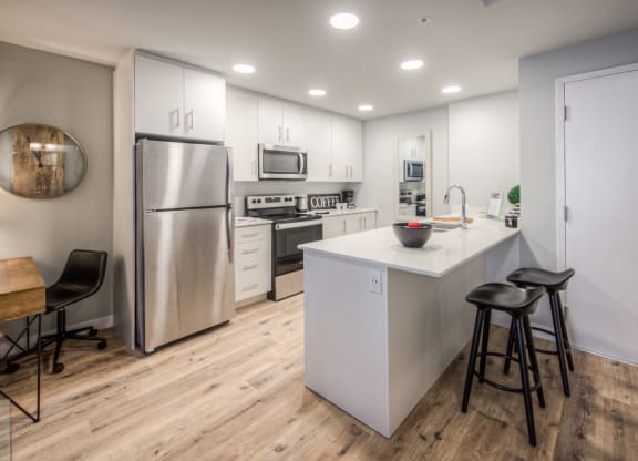 a kitchen with white cabinetry and stainless steel appliances