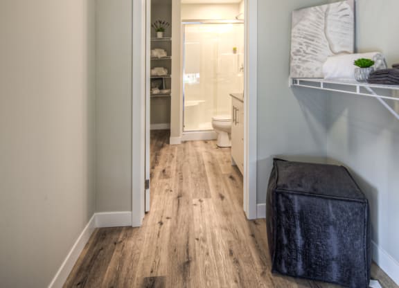 a bedroom with a bed and a stool in a room