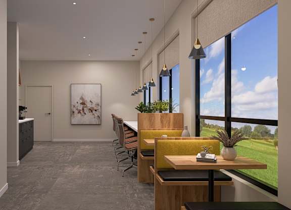 A modern office space with a view of the sky and greenery outside the windows.