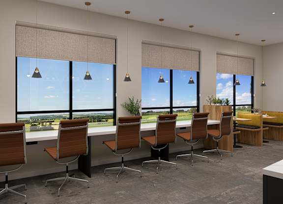 A conference room with a long table and chairs, a whiteboard, and a view of the outdoors through large windows.