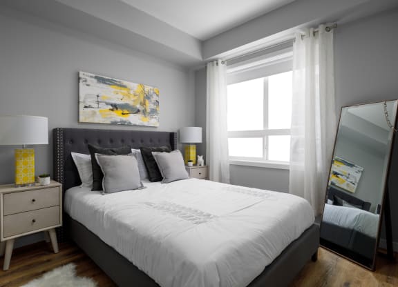 a bedroom with gray walls and a white bed