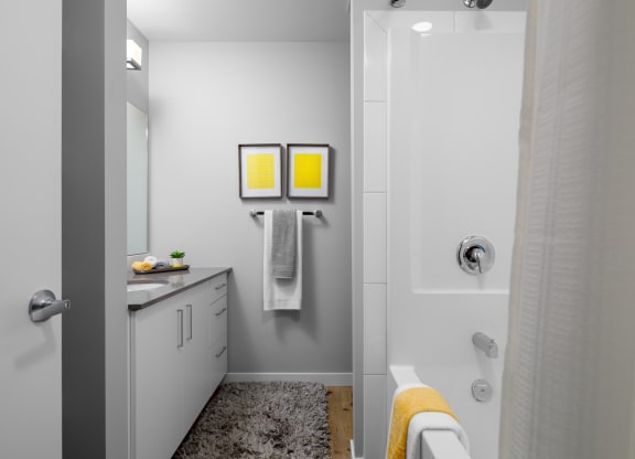a bathroom with a shower sink and bathtub in a 555 waverly unit