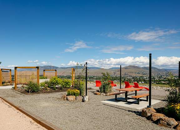 A park with a bench, a fence and a gate.