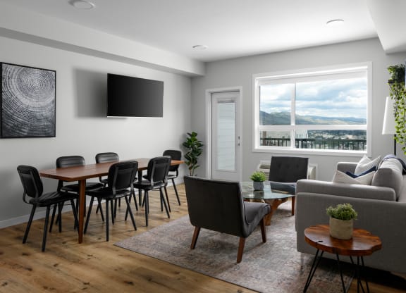 a living and dining area with a table and chairs and a flat screen tv on the wall