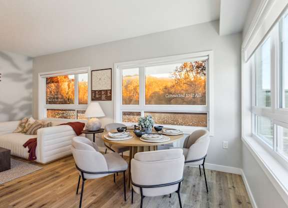 A dining room with a white couch and a table set for two.