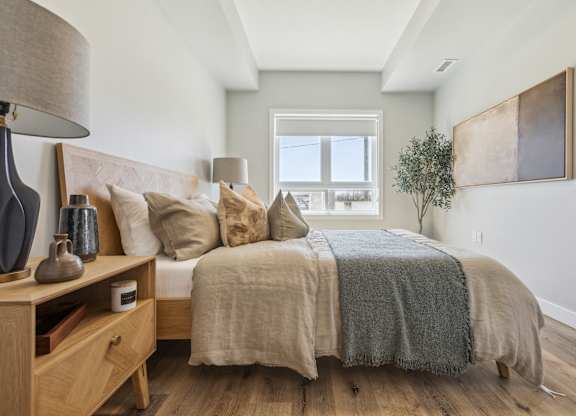 A bedroom with a bed, nightstand, and lamp.