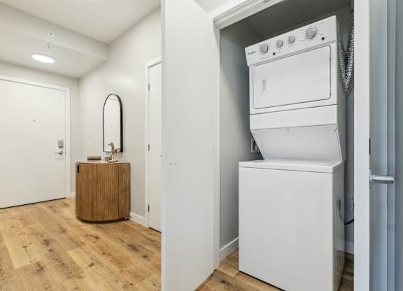 A white washing machine is in a small laundry room.