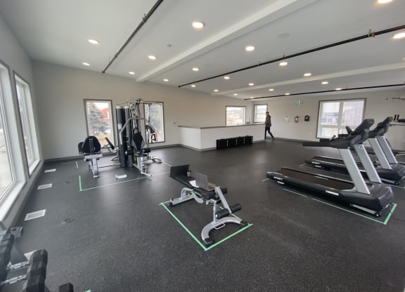 a large fitness room with treadmills and other exercise equipment