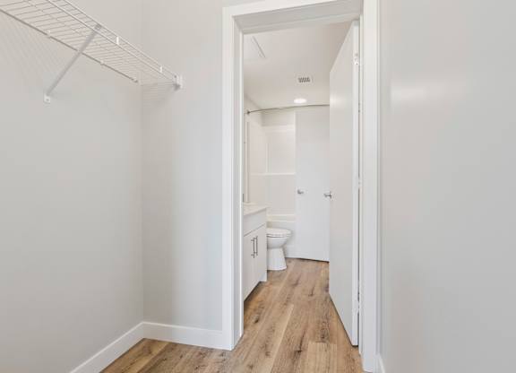 A white bathroom with a toilet, sink, and a walk-in shower.