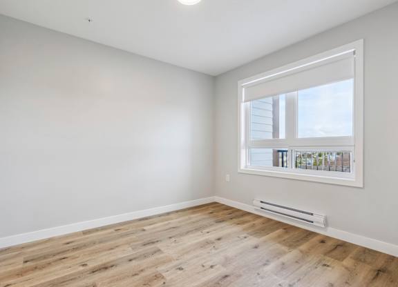 A room with a window and a radiator on the floor.