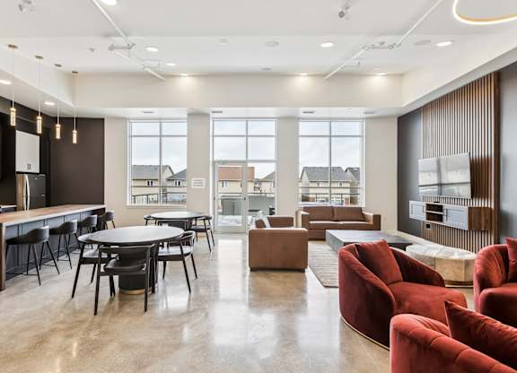 A modern living room with a kitchen area in the background.