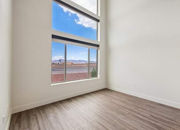 A room with a large window overlooking a road.