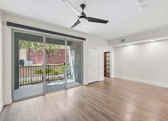 A room with a sliding glass door leading to a balcony.