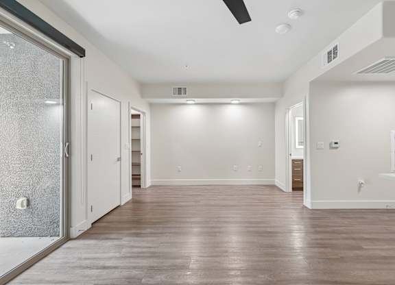 A spacious room with wooden floors and white walls.