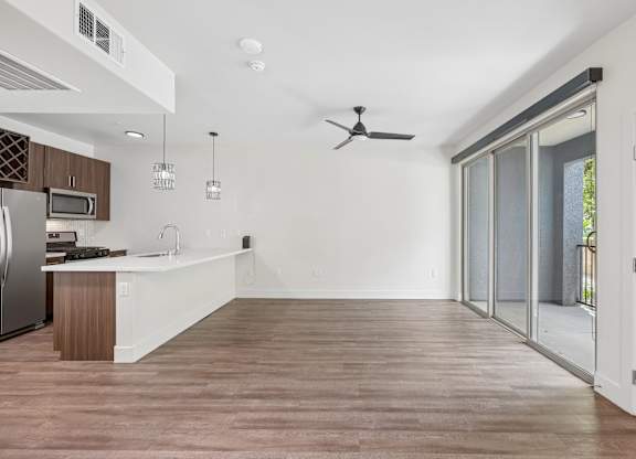 A modern kitchen with wooden floors and white walls.