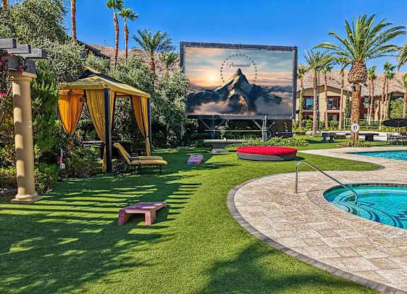 A backyard with a pool and a movie screen.