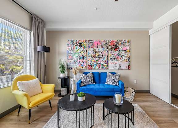 A living room with a yellow chair and a blue couch.
