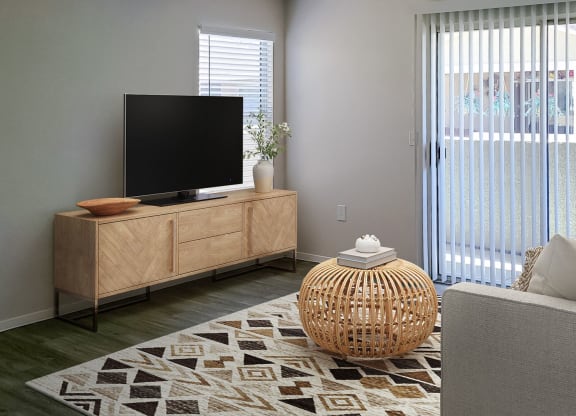 a living room with a tv on a stand in front of a sliding glass door at Silver Creek Apartments, Las Vegas, Nevada