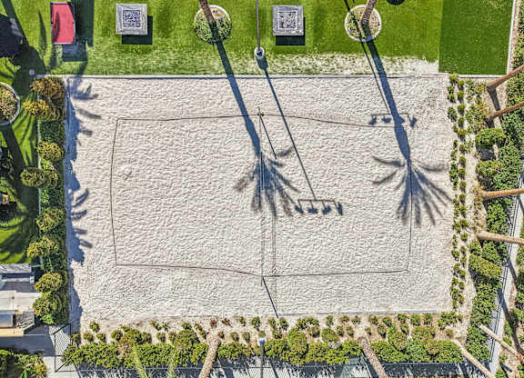 A sandy area with palm trees and a sign that says