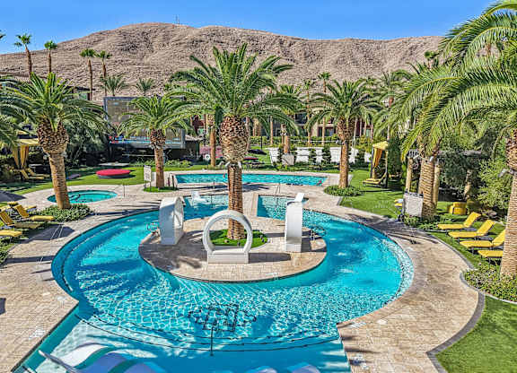 A large swimming pool surrounded by palm trees.