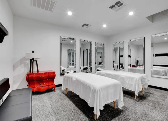 two beds in a room with mirrors and a red suitcase at Evoq Apartment Homes, Las Vegas  