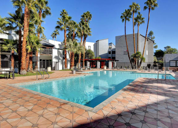 a large swimming pool in front of a hotel with palm trees at Evoq Apartment Homes, Nevada, 89169