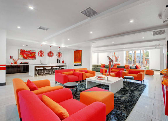 a living room with orange couches and chairs and a table at Evoq Apartment Homes, Nevada, 89169