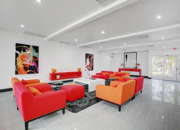 a living room with red and orange furniture and white walls at Evoq Apartment Homes, Las Vegas  