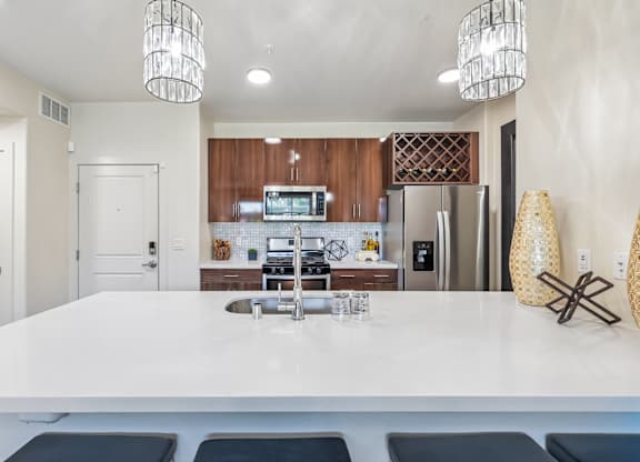 A modern kitchen with a white island and stainless steel appliances.