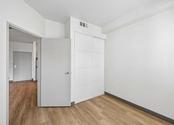 A white door is in a room with wood flooring.