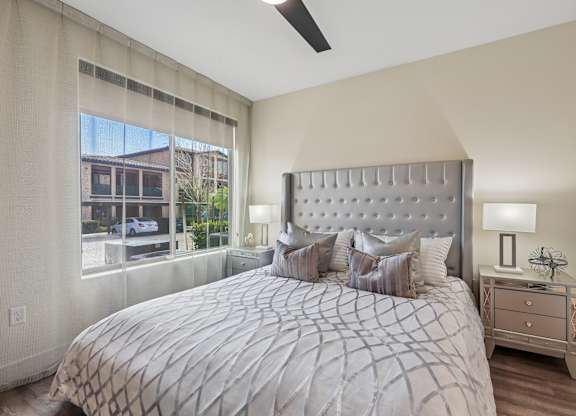 A bedroom with a large bed and a window overlooking a building.