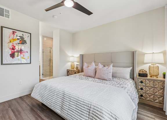 A bedroom with a large bed and a ceiling fan.