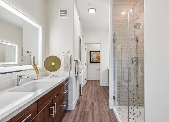 A bathroom with a white sink and a gold mirror.