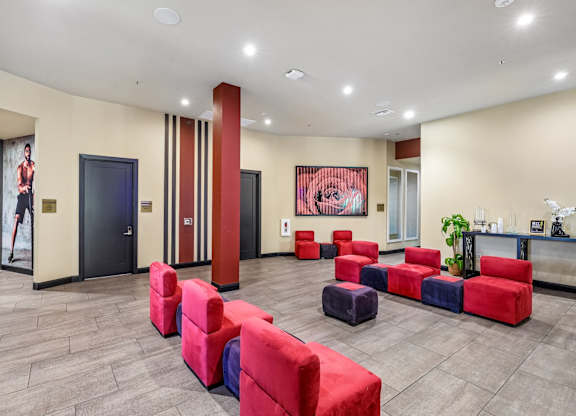 A room with red and blue couches and a painting on the wall.