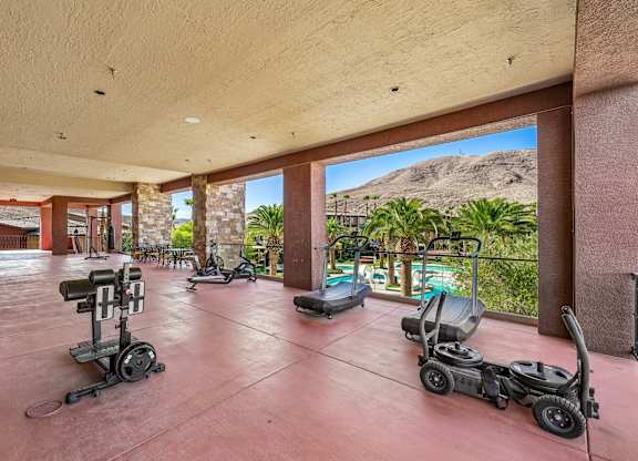 A gym with exercise equipment and a view of the mountains.
