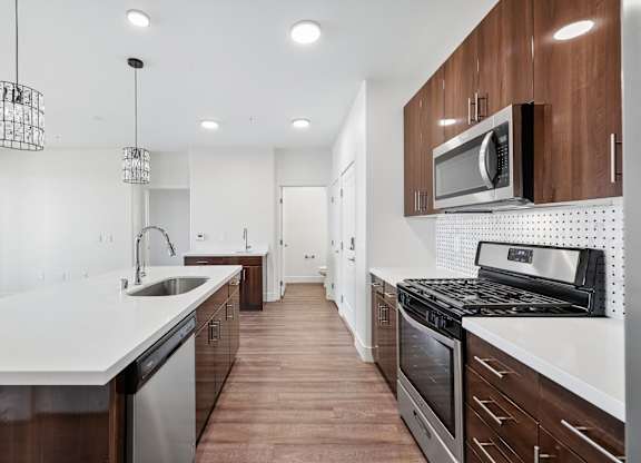 A modern kitchen with dark wood cabinets and white countertops.