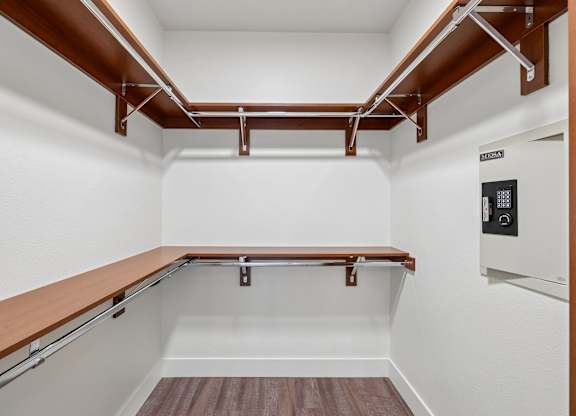 A white room with a wood shelf and a white appliance.